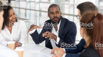 Millennial employees gathered in boardroom for training, black boss ceo leader leading corporate team during seminar learning at modern office. Internship and leadership coaching and education concept