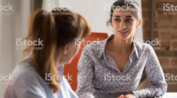 Indian businesswoman speaking to colleague or hr during job interview, young professional hindu woman manager consulting client or explaining giving advice teaching at business office meeting